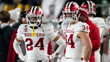 Indiana Hoosiers defensive back Bryson Bonds (24) and Indiana Hoosiers linebacker Jeff Utzinger (34) watch the second half of a game between the Indiana Hoosiers and the Notre Dame Fighting Irish in first round of the College Football Playoff on Saturday, Dec. 21, 2024, in South Bend. Notre Dame defeated Indiana 27-17.