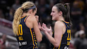 Indiana Fever guards Caitlin Clark and Lexie Hull talk during a timeout at Gainbridge Fieldhouse.