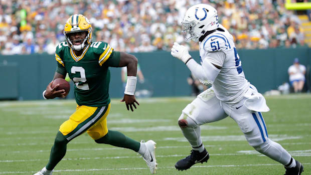 Colts defensive end Kwity Paye (all-white uniform) runs after Packers quarterback Malik Willis (green uniform). 