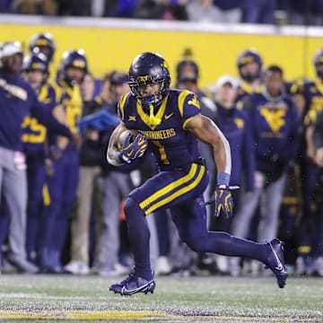Nov 23, 2024; Morgantown, West Virginia, USA; West Virginia Mountaineers running back Jahiem White (1) runs the ball against the UCF Knights during the third quarter at Mountaineer Field at Milan Puskar Stadium. Mandatory Credit: Ben Queen-Imagn Images