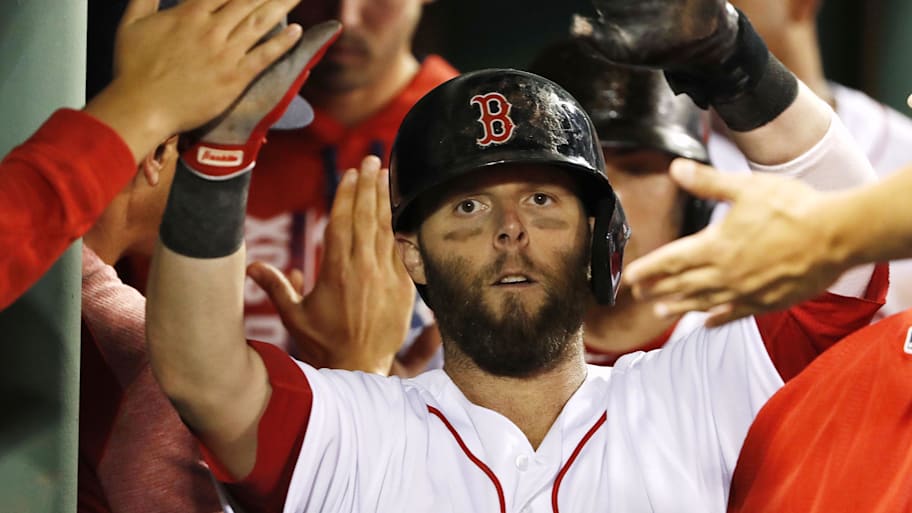 Boston Red Sox second baseman Dustin Pedroia is congratulated by teammates in the dugout 