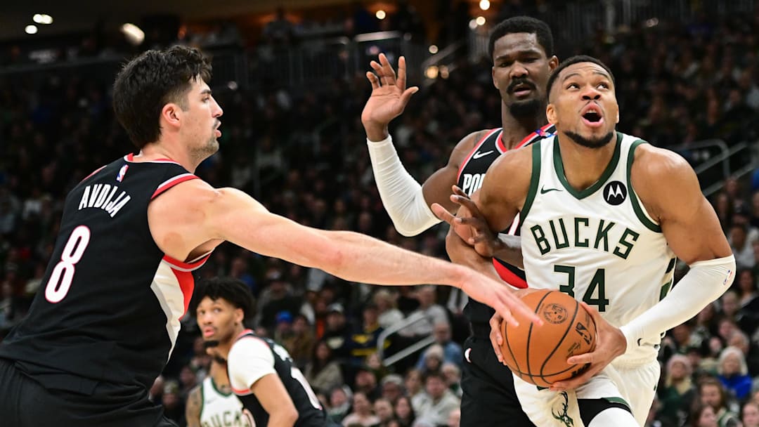 Jan 4, 2025; Milwaukee, Wisconsin, USA;  Milwaukee Bucks forward Giannis Antetokounmpo (34) looks for a shot against Portland Trail Blazers forward Deni Avdija (8) and  center Deandre Ayton (2) in the fourth quarter at Fiserv Forum. Mandatory Credit: Benny Sieu-Imagn Images