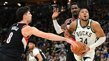 Jan 4, 2025; Milwaukee, Wisconsin, USA;  Milwaukee Bucks forward Giannis Antetokounmpo (34) looks for a shot against Portland Trail Blazers forward Deni Avdija (8) and  center Deandre Ayton (2) in the fourth quarter at Fiserv Forum. Mandatory Credit: Benny Sieu-Imagn Images