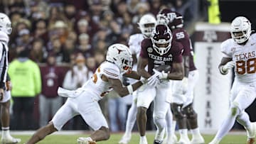 Nov 30, 2024; College Station, Texas, USA; Texas A&M Aggies wide receiver Terry Bussey (2) runs with the ball as Texas Longhorns linebacker Ty'Anthony Smith (26) attempts to make a tackle during the fourth quarter at Kyle Field. Mandatory Credit: Troy Taormina-Imagn Images