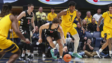 Feb 19, 2025; Morgantown, West Virginia, USA; Cincinnati Bearcats guard Dan Skillings Jr. (0) grabs a loose ball during the second half against the West Virginia Mountaineers at WVU Coliseum. Mandatory Credit: Ben Queen-Imagn Images