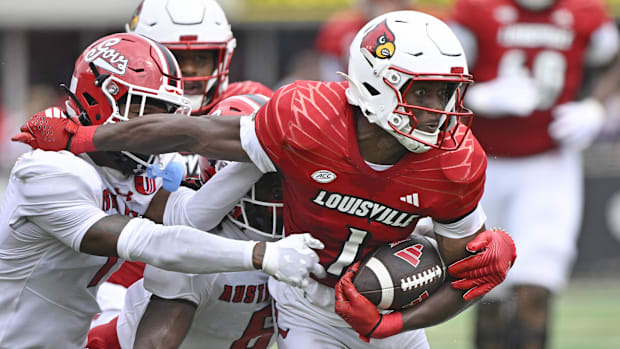 Louisville Cardinals wide receiver Ja'Corey Brooks (1) tries to escape the tackles of Austin Peay players.