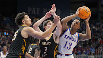 Oct 28, 2025; Lawrence, KS, USA; Kansas Jayhawks guard Elmarko Jackson (13) shoots against Fort Hays State Tigers forward Juju Ramirez (25) and guard Lucas Hammeke (3) during the second half at Allen Fieldhouse. Mandatory Credit: Jay Biggerstaff-Imagn Images