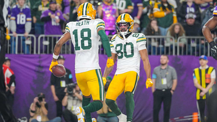 Dec 29, 2024; Minneapolis, Minnesota, USA; Green Bay Packers wide receiver Malik Heath (18) celebrates his touchdown with wide receiver Bo Melton (80) against Minnesota Vikings in the fourth quarter at U.S. Bank Stadium. Mandatory Credit: Brad Rempel-Imagn Images