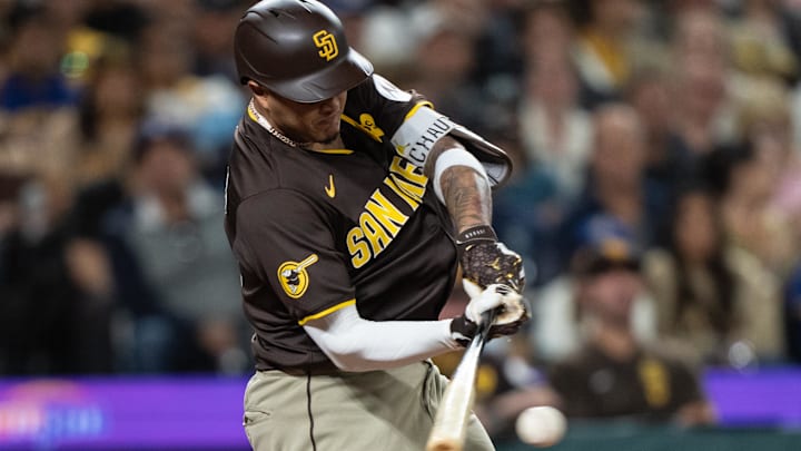 Sep 10, 2024; Seattle, Washington, USA;  San Diego Padres third baseman Manny Machado (13) hits a two-run single during the seventh inning against the Seattle Mariners at T-Mobile Park. Mandatory Credit: Stephen Brashear-Imagn Images