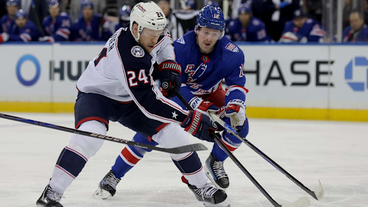 Mar 2, 2026; New York, New York, USA; Columbus Blue Jackets right wing Mathieu Olivier (24) plays the puck against New York Rangers left wing Alexis Lafreniere (13) during the first period at Madison Square Garden. Mandatory Credit: Brad Penner-Imagn Images
