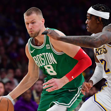 Dec 25, 2023; Los Angeles, California, USA; Boston Celtics center Kristaps Porzingis (8) moves to the basket against Los Angeles Lakers forward Jarred Vanderbilt (2) during the second half at Crypto.com Arena. Mandatory Credit: Gary A. Vasquez-Imagn Images