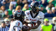 Oct 11, 2025; South Bend, Indiana, USA; NC State Wolfpack quarterback CJ Bailey (11) hands off to running back Hollywood Smothers (3) during the first half at Notre Dame Stadium. Mandatory Credit: Michael Caterina-Imagn Images