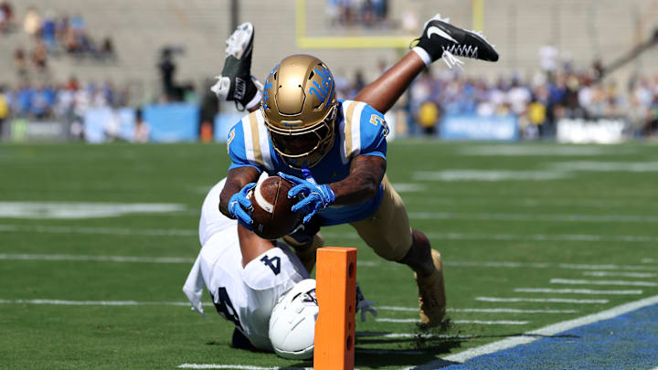 Oct 4, 2025; Pasadena, California, USA;  UCLA Bruins wide receiver Kwazi Gilmer (3) scores a touchdown against Penn State Nittany Lions cornerback AJ Harris (4) during the first quarter at Rose Bowl. Mandatory Credit: Kiyoshi Mio-Imagn Images