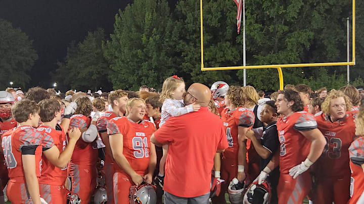 Mentor football coach Mat Gray gets a kiss from his daughter after defeating Medina on Sept. 8, 2023.