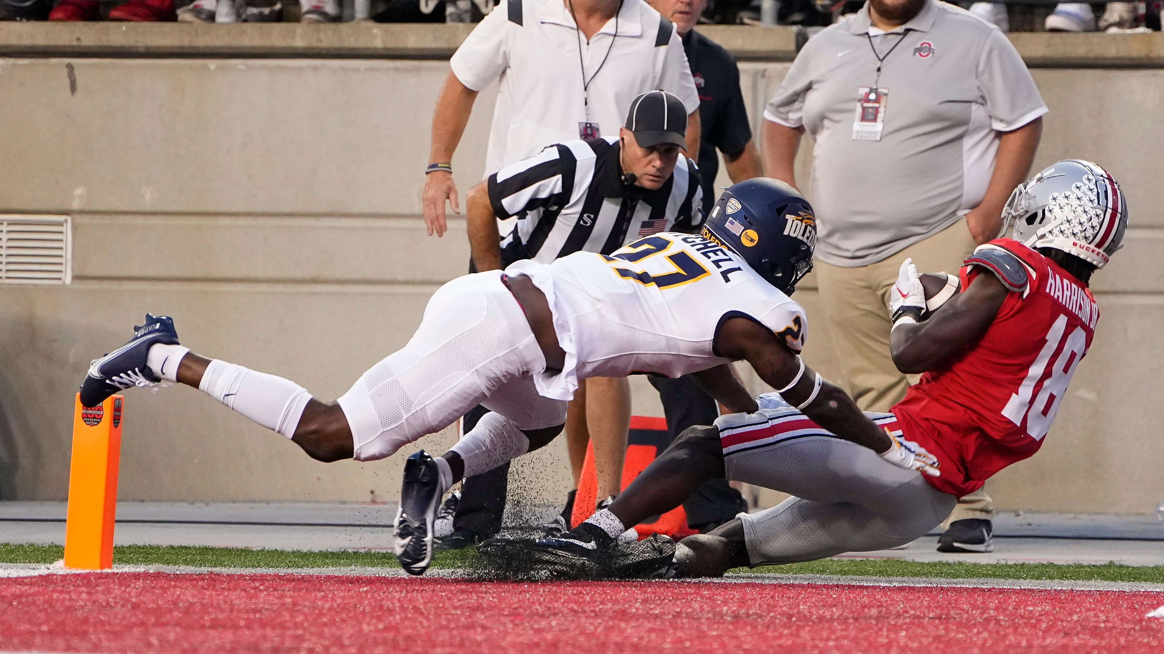 Ohio State Buckeyes wide receiver Marvin Harrison Jr. (18) is hit by Toledo's Quinyon Mitchell (27).