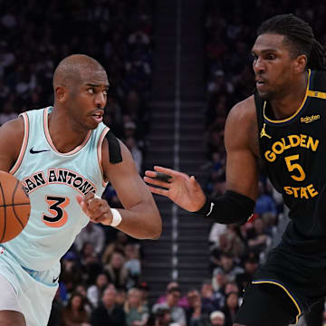 Apr 9, 2025; San Francisco, California, USA;  San Antonio Spurs guard Chris Paul (3) dribbles against Golden State Warriors forward Kevon Looney (5) in the fourth quarter at Chase Center. Mandatory Credit: David Gonzales-Imagn Images
