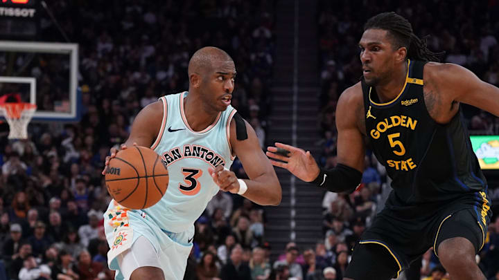 Apr 9, 2025; San Francisco, California, USA;  San Antonio Spurs guard Chris Paul (3) dribbles against Golden State Warriors forward Kevon Looney (5) in the fourth quarter at Chase Center. Mandatory Credit: David Gonzales-Imagn Images