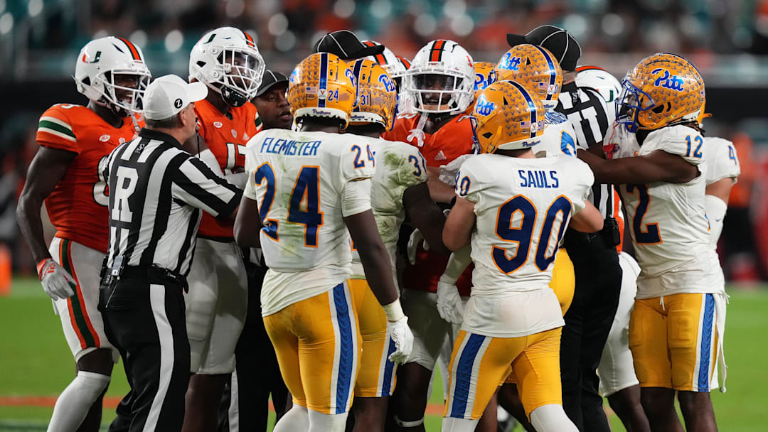 Nov 26, 2022; Miami Gardens, Florida, USA; Referees work to separate players from the Pittsburgh Panthers and Miami Hurricanes after a scuffle on the field during the second half at Hard Rock Stadium. Mandatory Credit: Jasen Vinlove-Imagn Images