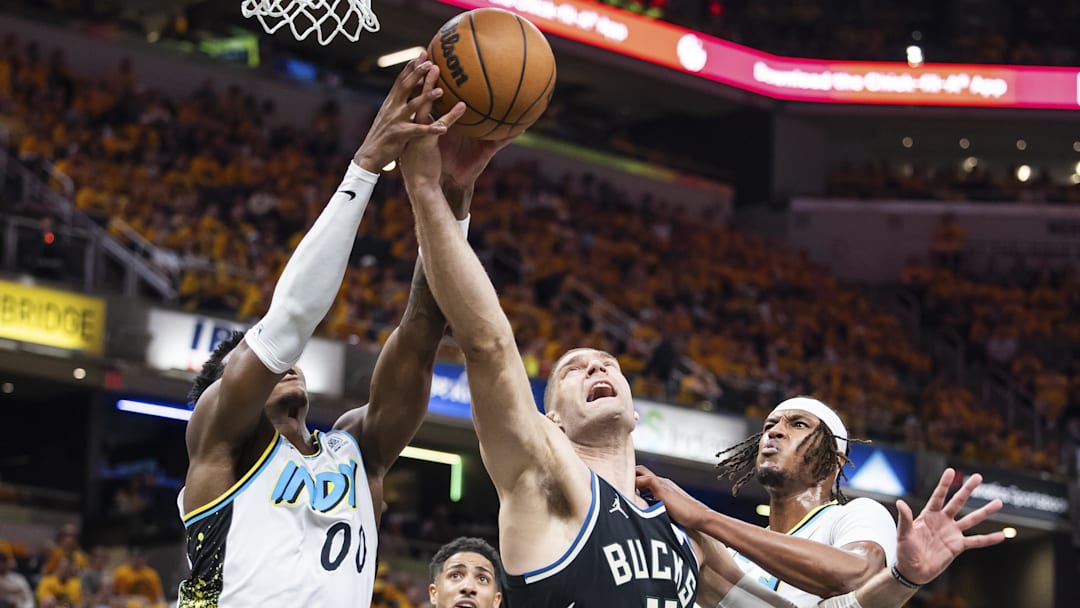 Apr 19, 2025; Indianapolis, Indiana, USA;  Indiana Pacers guard Bennedict Mathurin (00) and Milwaukee Bucks center Brook Lopez (11) fight for a rebound in the first half at Gainbridge Fieldhouse. Mandatory Credit: Trevor Ruszkowski-Imagn Images
