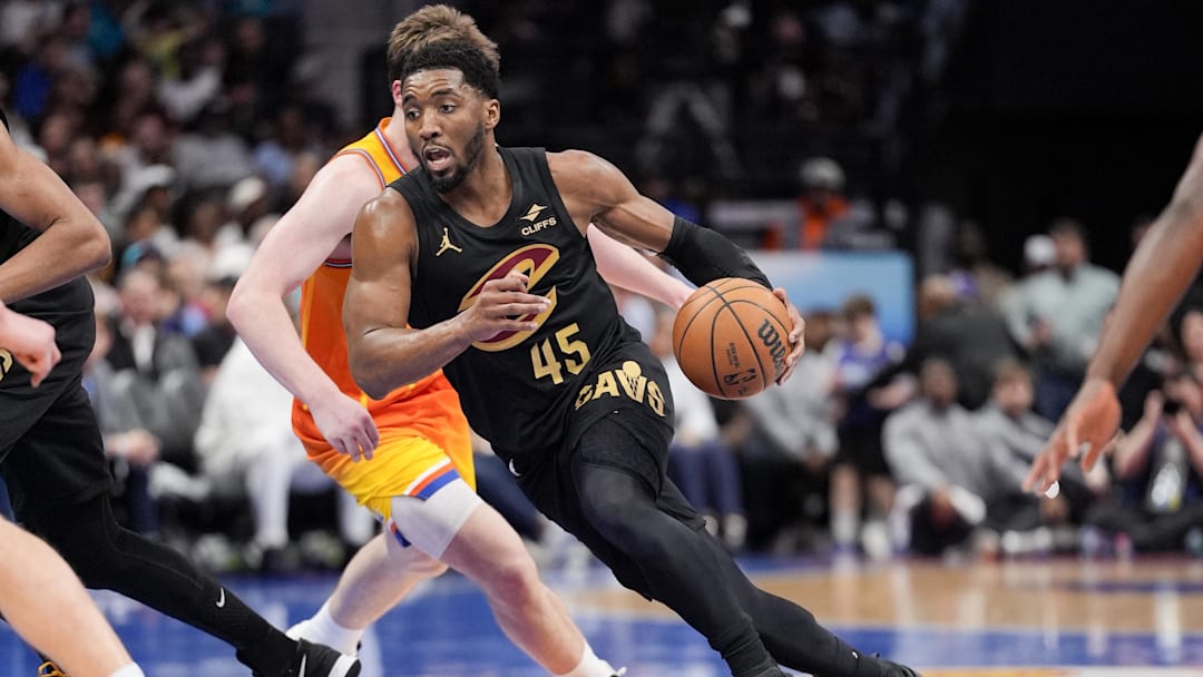 Feb 20, 2026; Charlotte, North Carolina, USA; Cleveland Cavaliers guard Donovan Mitchell (45) drives against Charlotte Hornets guard Kon Knueppel (7) during the second half at the Spectrum Center. Mandatory Credit: Jim Dedmon-Imagn Images