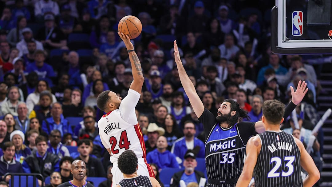 Dec 9, 2025; Orlando, Florida, USA; Miami Heat guard Norman Powell (24) shoots against Orlando Magic center Goga Bitadze (35) during the second half at Kia Center. Mandatory Credit: Mike Watters-Imagn Images