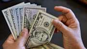 In this photo illustration, a person seen holding 5, 50, and...