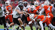 Iowa State Cyclones running back Carson Hansen stiff arms Miami Hurricanes defensive back Zaquan Patterson and Adarius Hayes