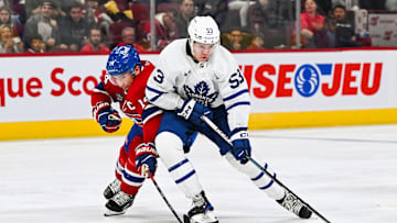 Sep 30, 2023; Montreal, Quebec, CAN; Toronto Maple Leafs right wing Easton Cowan (53) plays the puck against Montreal Canadiens center Nick Suzuki (14) during the third period at Bell Centre. Mandatory Credit: David Kirouac-Imagn Images