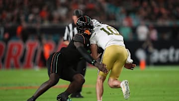 Oct 7, 2023; Miami Gardens, Florida, USA; Miami Hurricanes defensive lineman Nyjalik Kelly (9) tackles Georgia Tech Yellow Jackets quarterback Haynes King (10) in the first half at Hard Rock Stadium. Mandatory Credit: Jasen Vinlove-Imagn Images