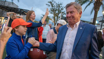 National championship-winning head coach Steve Spurrier signs an attendee's football during the unveiling of Steve Spurrier Way at Celebration Pointe in Gainesville, Fla., on Feb. 10, 2023.