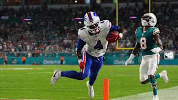 Sep 12, 2024; Miami Gardens, Florida, USA; Buffalo Bills running back James Cook (4) runs for a touchdown past Miami Dolphins safety Jevon Holland (8) during the first half at Hard Rock Stadium. Mandatory Credit: Jasen Vinlove-Imagn Images