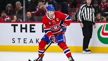 Mar 22, 2025; Montreal, Quebec, CAN; Montreal Canadiens center Nick Suzuki (14) plays the puck against the Colorado Avalanche in shootout at Bell Centre. Mandatory Credit: David Kirouac-Imagn Images
