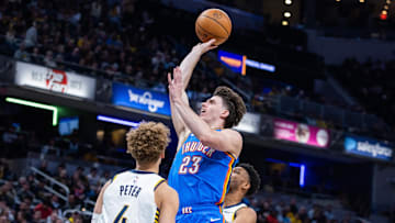 Oct 23, 2025; Indianapolis, Indiana, USA; Oklahoma City Thunder forward Brooks Barnhizer (23) shoots the ball while Indiana Pacers guard Taelon Peter (4) defends in the first half at Gainbridge Fieldhouse. Mandatory Credit: Trevor Ruszkowski-Imagn Images