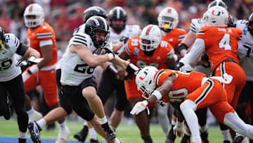 Iowa State Cyclones running back Carson Hansen stiff arms Miami Hurricanes defensive back Zaquan Patterson and Adarius Hayes