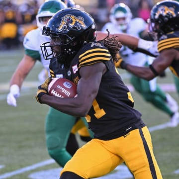Jun 16, 2024; Hamilton, Ontario, CAN; Hamilton Tiger Cats defensive back Lawrence Woods III carries the ball in the second half against the Saskatchewan Rough Riders at Tim Hortons Field. Mandatory Credit: Gerry Angus-USA TODAY Sports