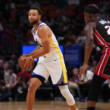 Golden State Warriors guard Stephen Curry (30) and Miami Heat forward Jimmy Butler (22) during the first half at FTX Arena.