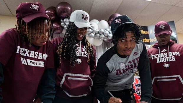 Melrose’s Jamarion Morrow looks up after signing to play football at Texas A&M.