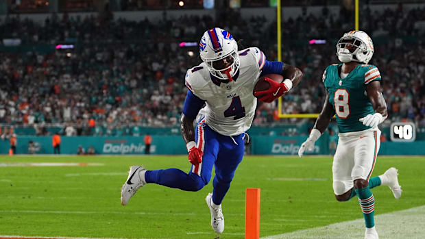 Buffalo Bills running back James Cook (4) runs for a touchdown past Miami Dolphins safety Jevon Holland (8).