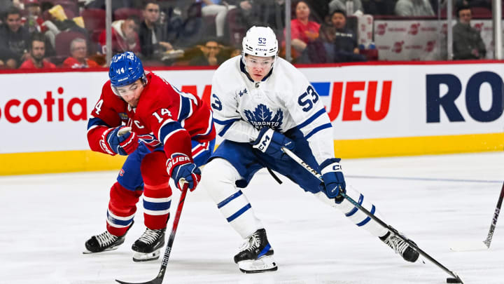 Sep 30, 2023; Montreal, Quebec, CAN; Toronto Maple Leafs right wing Easton Cowan (53) plays the puck against Montreal Canadiens center Nick Suzuki (14) during the third period at Bell Centre. Mandatory Credit: David Kirouac-USA TODAY Sports
