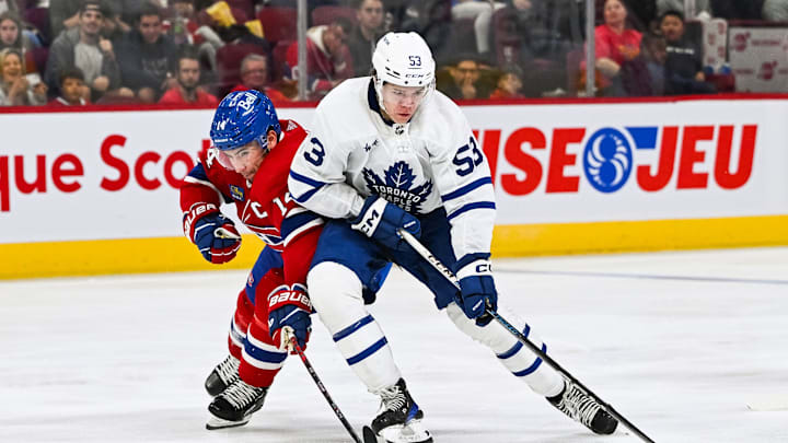 Sep 30, 2023; Montreal, Quebec, CAN; Toronto Maple Leafs right wing Easton Cowan (53) plays the puck against Montreal Canadiens center Nick Suzuki (14) during the third period at Bell Centre. Mandatory Credit: David Kirouac-Imagn Images