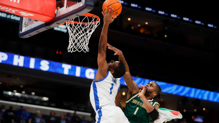 Memphis' Jayhlon Young (1) collides with South Florida's Selton Miguel (1) as he goes to dunk the ball during the game between the University of South Florida and the University of Memphis at FedExForum in Memphis, Tenn., on Thursday, January 18, 2024. USF defeated Memphis 74-73.