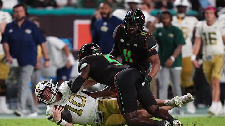 Oct 7, 2023; Miami Gardens, Florida, USA; Miami Hurricanes safety Kamren Kinchens (5) tackles Georgia Tech Yellow Jackets quarterback Haynes King (10) in the first half at Hard Rock Stadium. Mandatory Credit: Jasen Vinlove-Imagn Images