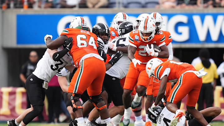 Dec 28, 2024; Orlando, FL, USA; Miami Hurricanes running back Jordan Lyle (21) runs the ball against the Iowa State Cyclones during the first half at Camping World Stadium. Mandatory Credit: Jasen Vinlove-Imagn Images