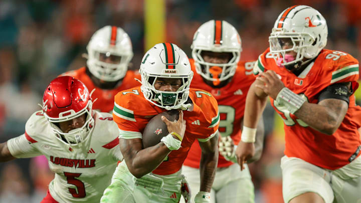 Oct 17, 2025; Miami Gardens, Florida, USA; Miami Hurricanes safety Zechariah Poyser (7) recovers a fumble against the Louisville Cardinals during the fourth quarter at Hard Rock Stadium. Mandatory Credit: Sam Navarro-Imagn Images