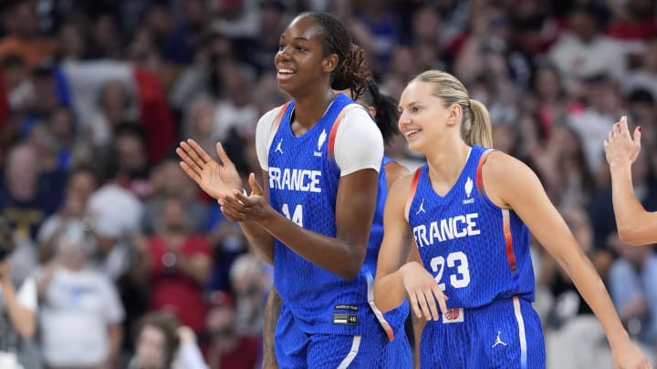 Jul 29, 2024; Villeneuve-d'Ascq, France; France center Dominique Malonga (14) and guard Marine Johannes (23) celebrate after defeating Canada during the Paris 2024 Olympic Summer Games at Stade Pierre-Mauroy. Mandatory Credit: John David Mercer-USA TODAY Sports