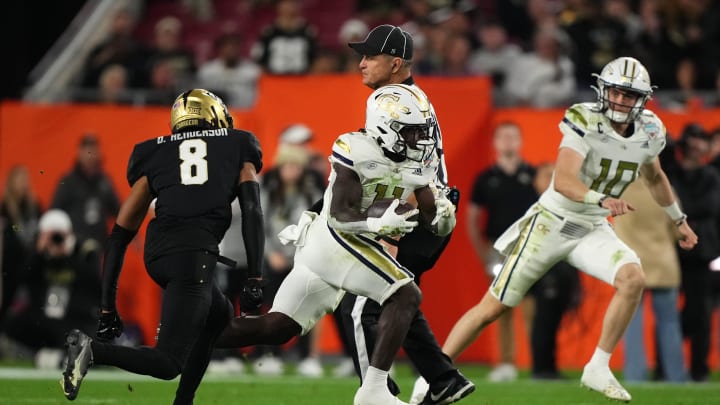 Dec 22, 2023; Tampa, FL, USA; Georgia Tech Yellow Jackets running back Jamal Haynes (11) runs the ball past UCF Knights defensive back Demari Henderson (8) during the second half of the Gasparilla Bowl at Raymond James Stadium. Mandatory Credit: Jasen Vinlove-USA TODAY Sports