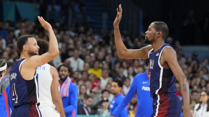 Aug 3, 2024; Villeneuve-d'Ascq, France; United States guard Kevin Durant (7) celebrates with shooting guard Stephen Curry (4) in the second quarter against Puerto Rico during the Paris 2024 Olympic Summer Games at Stade Pierre-Mauroy. Mandatory Credit: John David Mercer-USA TODAY Sports