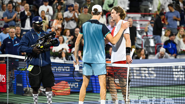 Jannik Sinner and Andrey Rublev meet at the net.