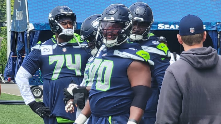 Seahawks guards Laken Tomlinson and McClendon Curtis listen for instructions prior to a drill during an OTA practice.