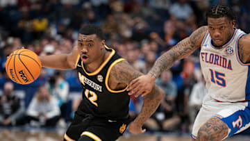Missouri Tigers guard Tony Perkins (12) drives past Florida Gators guard Alijah Martin (15) during the second half of their quarterfinal game of the SEC Men's Basketball Tournament at Bridgestone Arena in Nashville, Tenn., Friday, March 14, 2025.